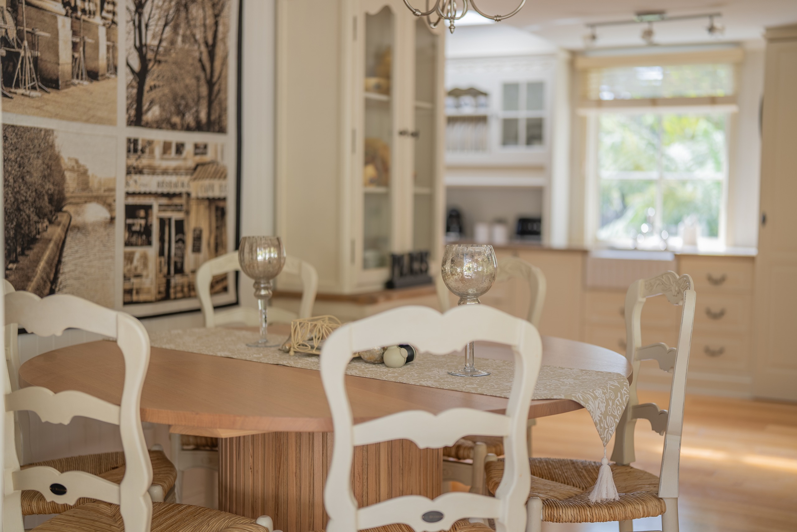A round dining table with white chairs set beside the kitchen.