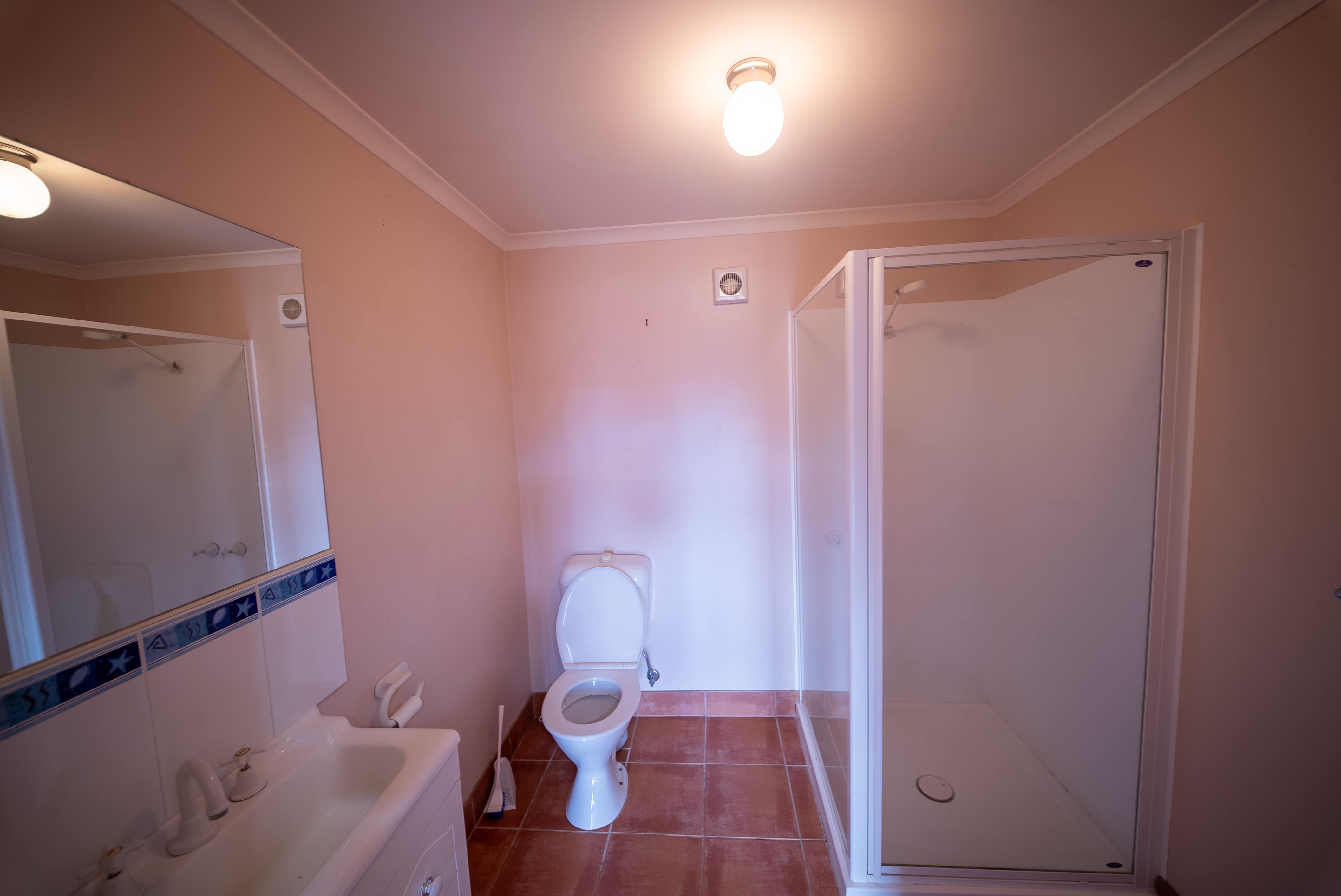 Downstairs bathroom with a shower, a toilet and a vanity.