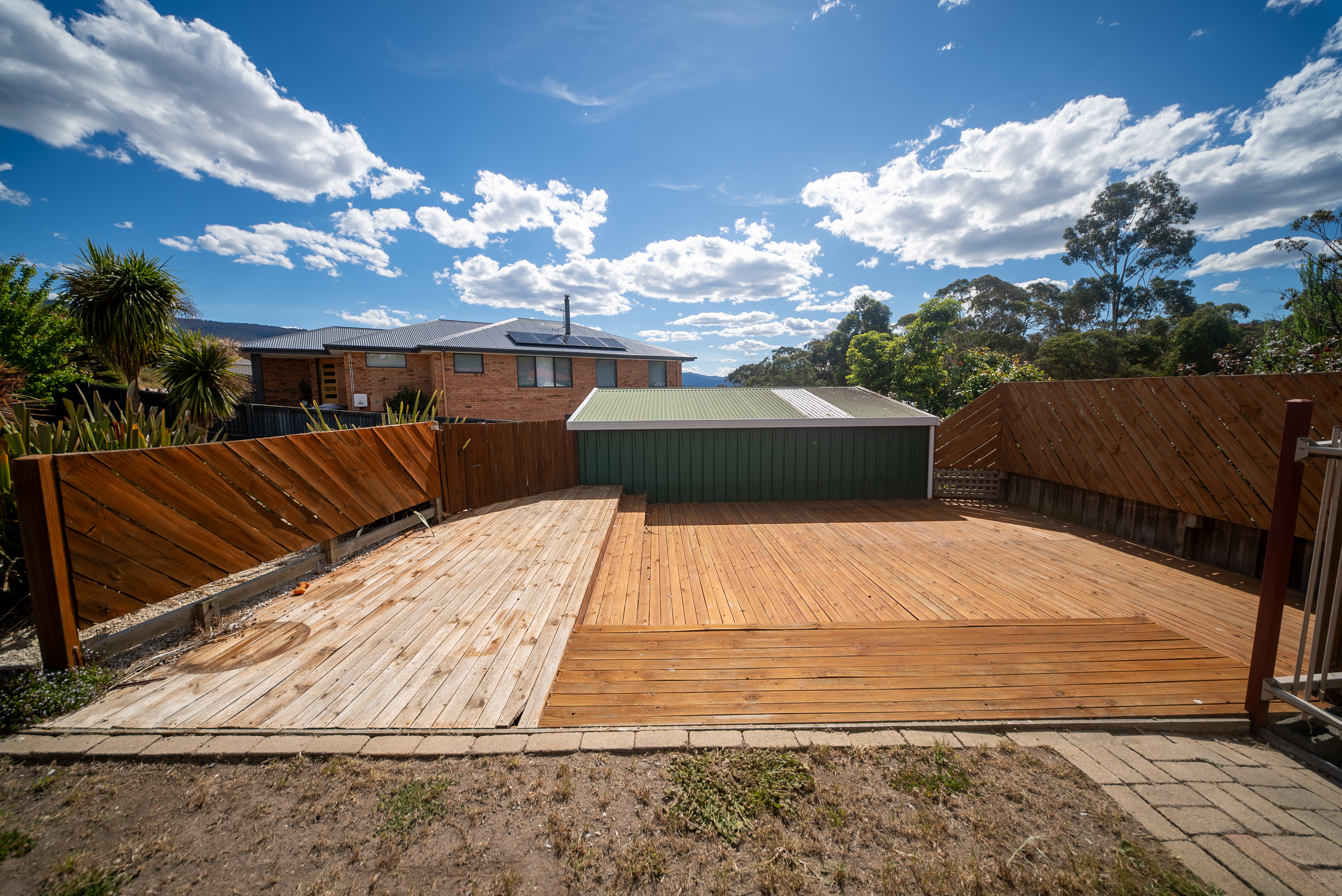 Timber deck in the fenced backyard, with the garage behind.