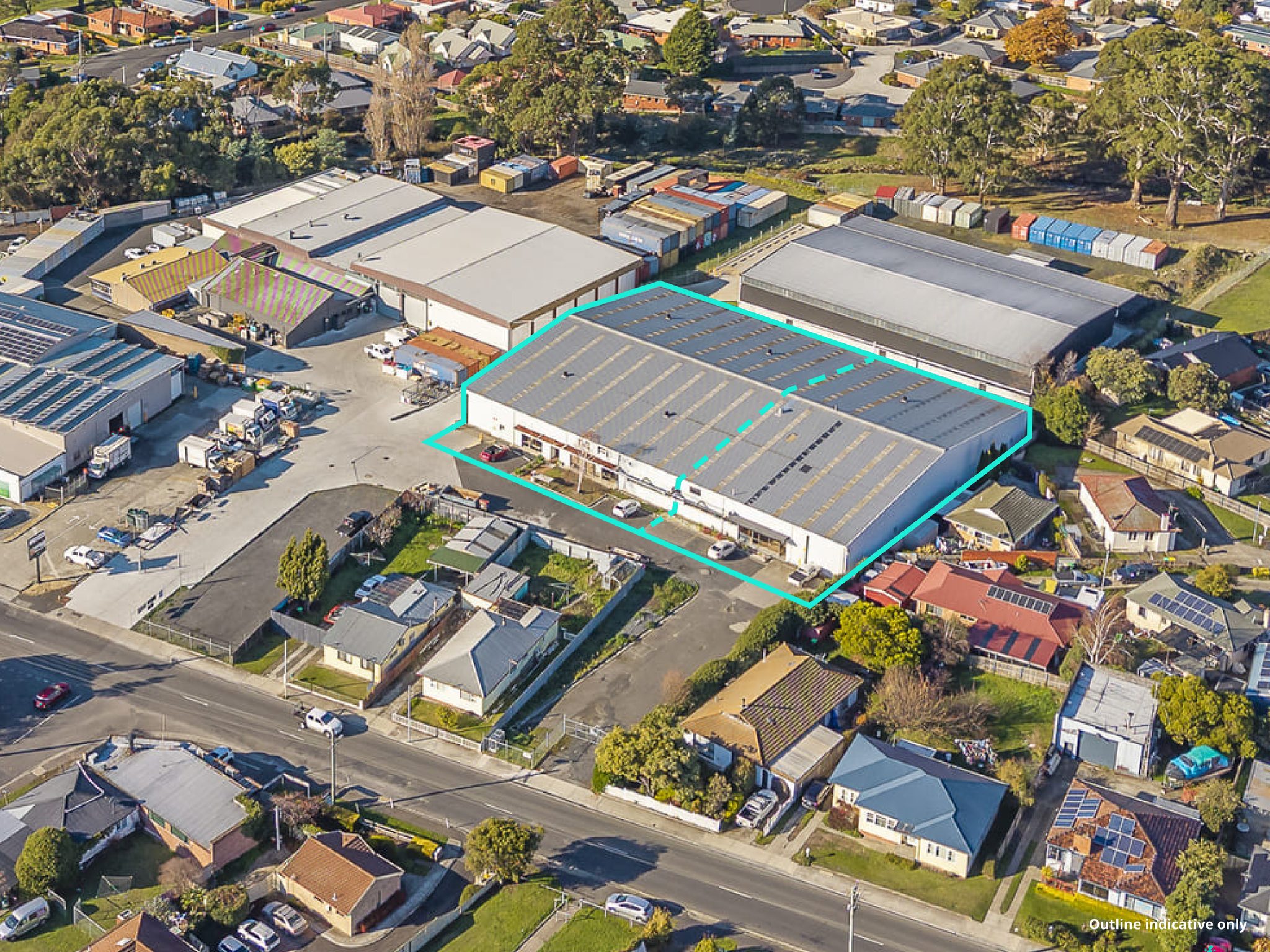 Aerial photograph with the site boundary outlined and a dashed line marking a division across the building.